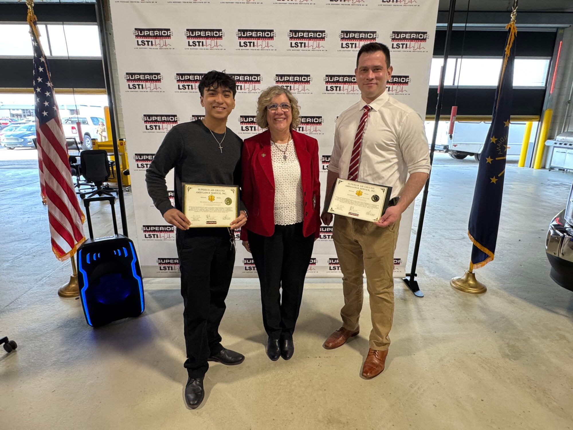 2 EMT class graduates pose for a photo with a state rep